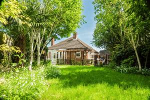 een huis met een tuin met groen gras bij P&M Happy Bungalow in Sunbury Common