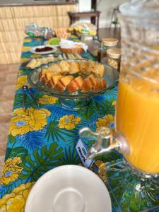 a table with a plate of food and a glass of orange juice at Pousada Mawe in Paraty