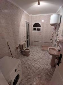 a bathroom with a washing machine and a toilet at Spacious 3 bedroom apartment with a sea view. in Dawwār Abū Maḩrūs