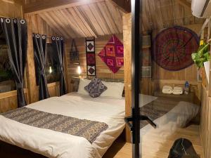 ein Schlafzimmer mit einem Bett in einem Zimmer mit Holzwänden in der Unterkunft MAI HICH FARMSTAY 2 in Mai Hạ