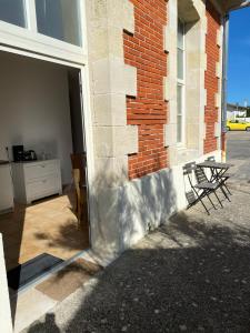 a door to a brick building with two chairs at Appartement familial centre et plage in Soulac-sur-Mer