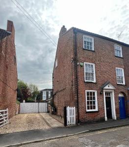 a red brick house with a white door on a street at York House in Retford