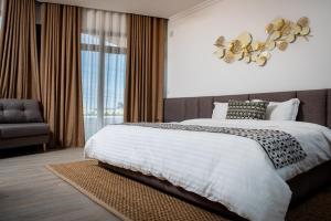 Un dormitorio con una gran cama blanca y una ventana en MERCURE HOTEL en Antananarivo