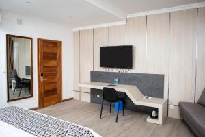 a hotel room with a desk and a tv on the wall at MERCURE HOTEL in Antananarivo