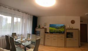 a living room with a dining table and a television at Na Kamiennej in Kołobrzeg