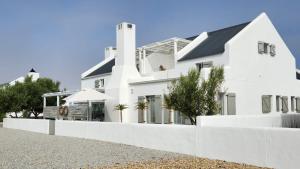 a white house with a white fence in front of it at Ciao in Paternoster