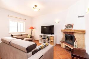 a living room with a couch and a fireplace at Moradia Rainbow by ALGARVEMANTA in Manta Rota