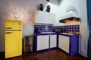 a kitchen with a yellow refrigerator and purple tiles at Bellini Inn Primo Piano in Naples
