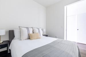 a bedroom with a large white bed with pillows at Capitol Hill 1BR w WD Rooftop Lounge nr park SEA-133 in Seattle