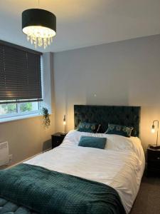 Un dormitorio con una cama grande y una lámpara de araña. en Modern 1 Bed Apartment in Mansfield Town Centre, en Mansfield