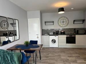 a living room with a table and a kitchen at Modern 1 Bed Apartment in Mansfield Town Centre in Mansfield