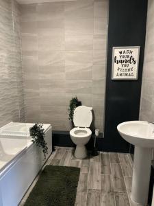 a bathroom with a toilet and a sink and a tub at Modern 1 Bed Apartment in Mansfield Town Centre in Mansfield