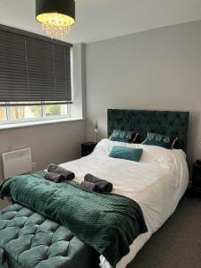 a bedroom with a large bed with a green headboard at Modern 1 Bed Apartment in Mansfield Town Centre in Mansfield