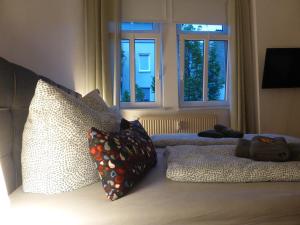 a bedroom with pillows on a bed with two windows at Jena City Apartment, Balkon, sonnig, Wifi, Parkplätze, Nähe Zentrum in Jena
