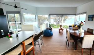 a living room with a dining room table and chairs at Beach Getaway - Blessington Villa in South Arm
