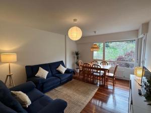 a living room with a blue couch and a table at SUKARRIETA Urdaibai in Pedernales