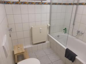 a bathroom with a tub and a toilet and a sink at Jena City Apartment, Balkon, sonnig, Wifi, Parkplätze, Nähe Zentrum in Jena +29 photos