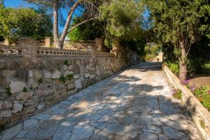 a stone path next to a stone wall at Palazzo Di Angelo in Zakynthos