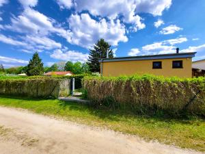 a house with hay bales in front of a dirt road at Ferienhaus Seeperle in Wesenberg
