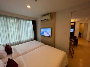 バンコクにあるアリゼ ホテル スクンビットのベッド2台、薄型テレビが備わるホテルルームです。