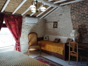 a bedroom with a bed and a chair in a room at L'Ecrin des Roches in Le Langon +21 photos
