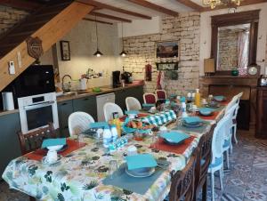 a long dining room table with chairs and a kitchen at Chez Marek et Urszula in Le Langon