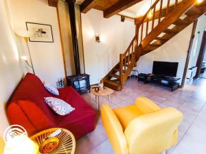 ein Wohnzimmer mit einem roten Sofa und einem TV in der Unterkunft Gîte La Petite Fagette in Frayssinet-le-Gélat