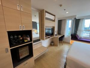 a hotel room with a bed and a desk in it at Arize Hotel Sukhumvit in Bangkok