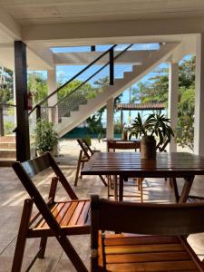 une terrasse avec des tables et des chaises en bois et des escaliers. dans l'établissement Pousada Mawe, à Parati
