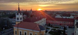 a view of a city with a church and a sunset at Over the City in Oradea