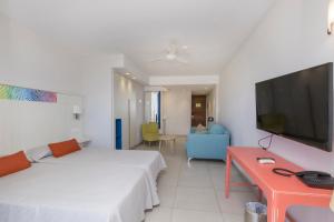 sypialnia z łóżkiem, telewizorem i kanapą w obiekcie Hotel LIVVO Veril Playa w mieście Playa del Ingles