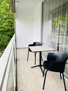 einen Balkon mit einem Tisch und Stühlen sowie einem Fenster in der Unterkunft Appartement 202 in Klagenfurt am Wörthersee