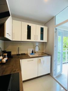 eine Küche mit weißen Schränken und einem Waschbecken in der Unterkunft Appartement 202 in Klagenfurt am Wörthersee