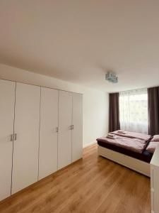 ein weißes Schlafzimmer mit einem Bett und weißen Schränken in der Unterkunft Appartement 202 in Klagenfurt am Wörthersee