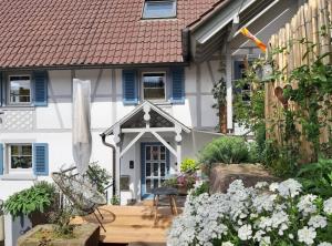 a garden in front of a house with blue shutters at Ferienwohnung Silvi und Heinz Huber in Durbach