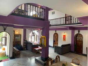 una sala de estar con paredes de color púrpura y una habitación grande con en Tashila Hostel, en Gangtok
