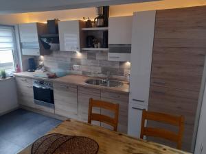 a kitchen with a sink and a table with chairs at Ferienwohnung Beckmann in Bad Lauterberg +17 photos