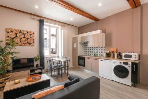 a living room with a couch and a kitchen at Cabana & Le Petit Carnot - Centre-Ville in Tournus