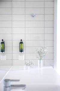 a bathroom with two candles and flowers in a vase at Frogner House - Vika in Oslo