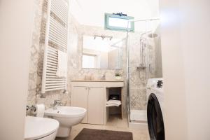 a bathroom with a sink and a toilet and a mirror at Dimora Nonna Lina in San Michele Salentino