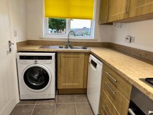 a kitchen with a washing machine and a sink at Steeple House in Higham Ferrers