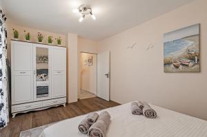 a bedroom with a bed with towels on it at Апартаменти Ивайло / Ivaylo apartments in Burgas City