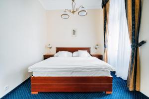 1 dormitorio con 1 cama con sábanas blancas en OREA Place Marienbad, en Mariánské Lázně
