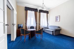 a living room with a couch and a table and chairs at OREA Place Marienbad in Mariánské Lázně