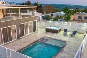 a swimming pool on the roof of a house at Alice Suites in Zar‘it