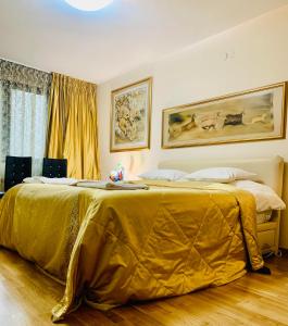 a bedroom with a bed with a gold blanket on it at Тorino luxury с гараж in Sofia