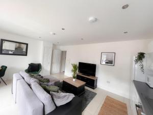 a living room with a couch and a tv at Gorgeous apartment with free parking in Southampton