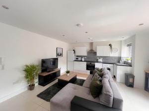 a living room with a couch and a kitchen at Gorgeous apartment with free parking in Southampton