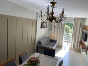 a living room with a dining table and a chandelier at Hotel APART Zuccolotto 303 in Aracruz