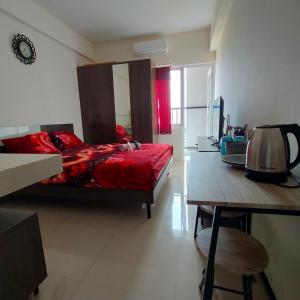 1 dormitorio con cama roja y mesa en RB Room Bogorienze The Jungle Bogor en Bogor